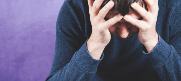 A dad with his head in his hands wondering why teenage years are so difficult